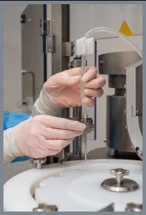 Mains gantées changeant une aiguille de machine de remplissage pharmaceutique